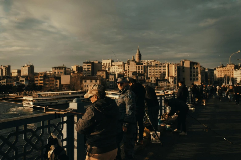 people stand on the edge of a city bridge overlooking a body of water