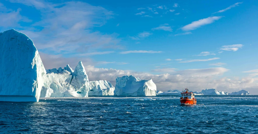 a small orange boat sailing in a large body of water