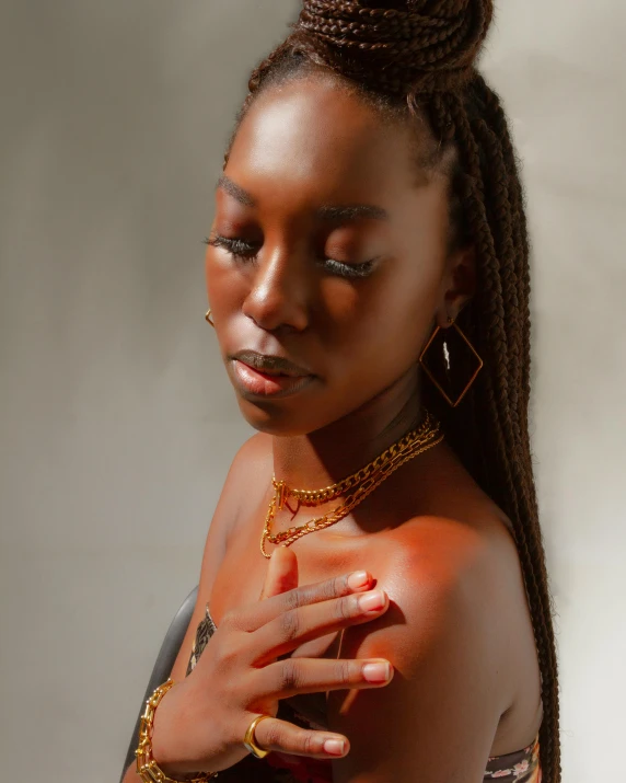 a young black woman is in a white room wearing a chain and a red shirt