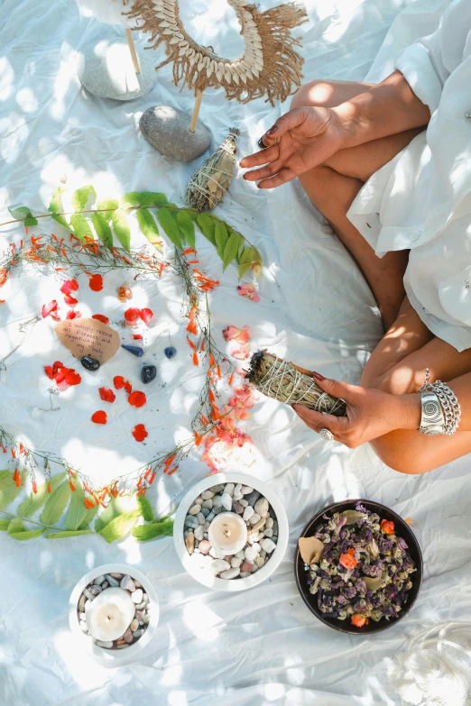 the woman is decorating some flowers on her picnic blanket