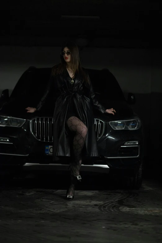 a girl in a black outfit is standing next to a car