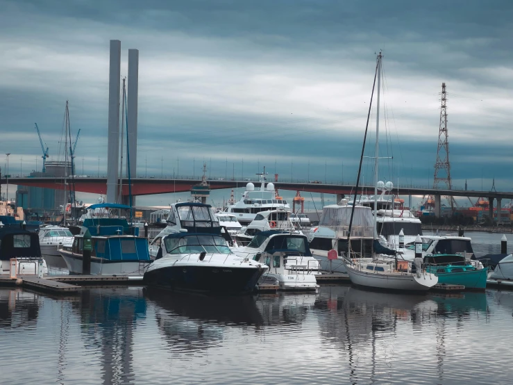 several boats docked in a harbor under the bridge