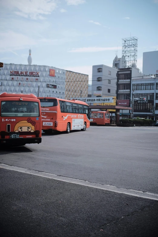 buses parked in a parking lot next to buildings