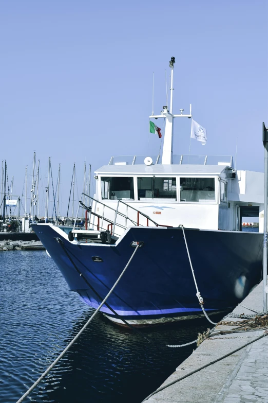 a blue and white boat docked next to the water