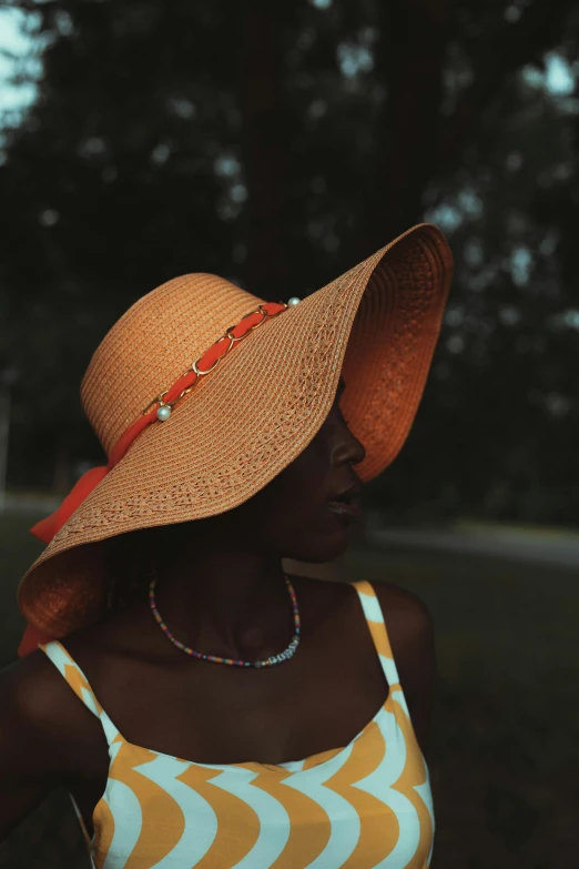 the woman's hat is beige and has a red ribbon around it