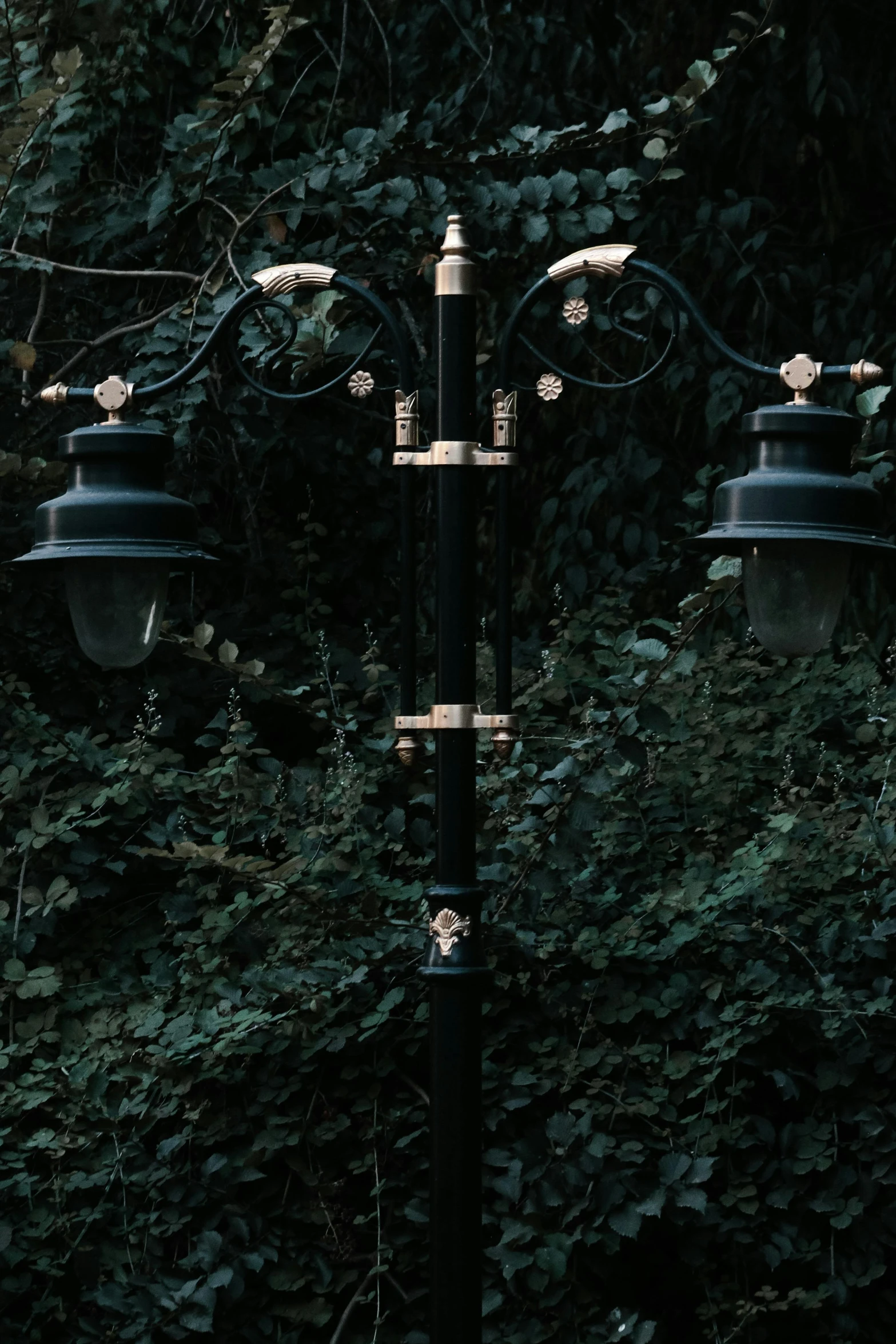 three lamps that are hanging from a pole