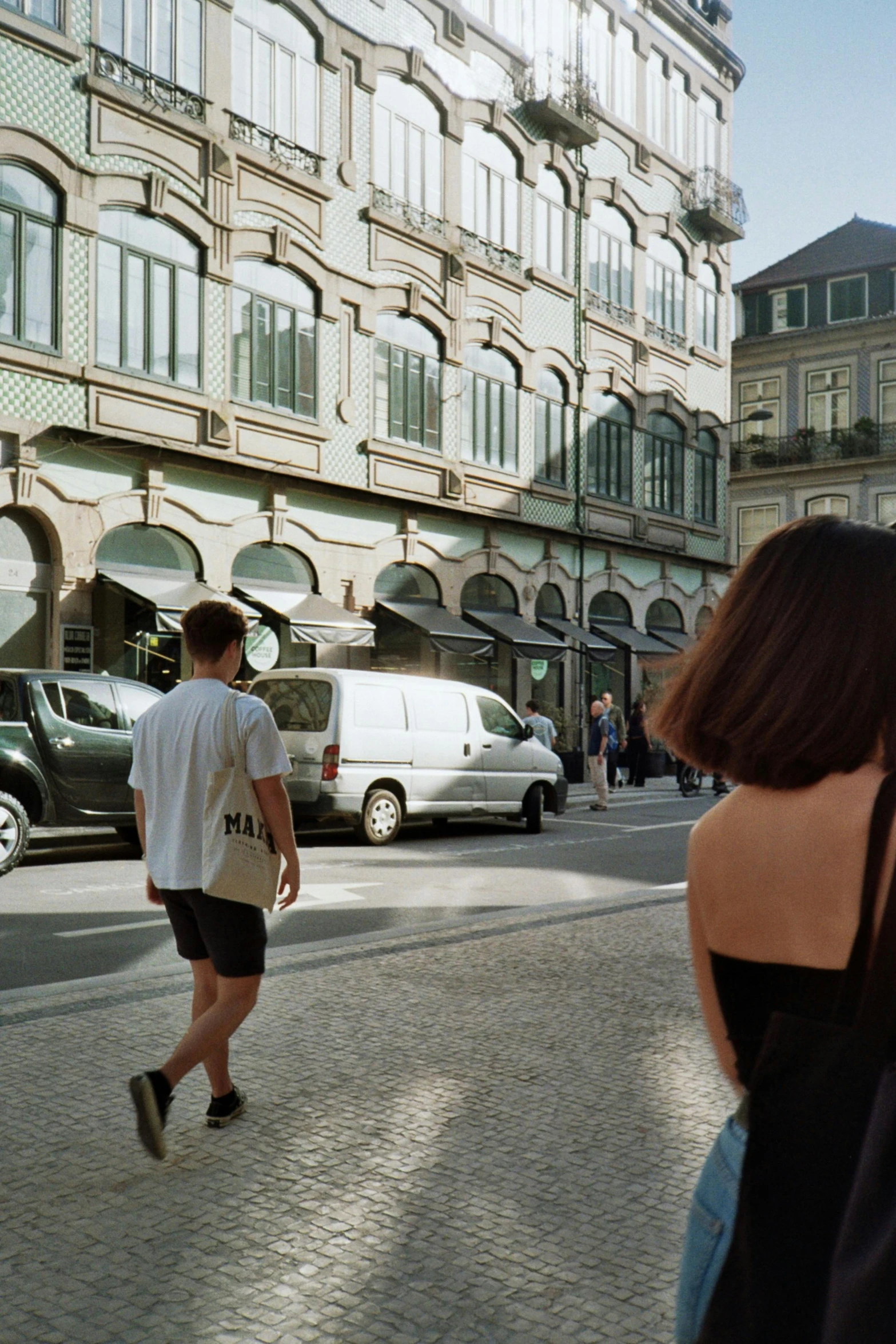 two people walking through an empty cobblestone street