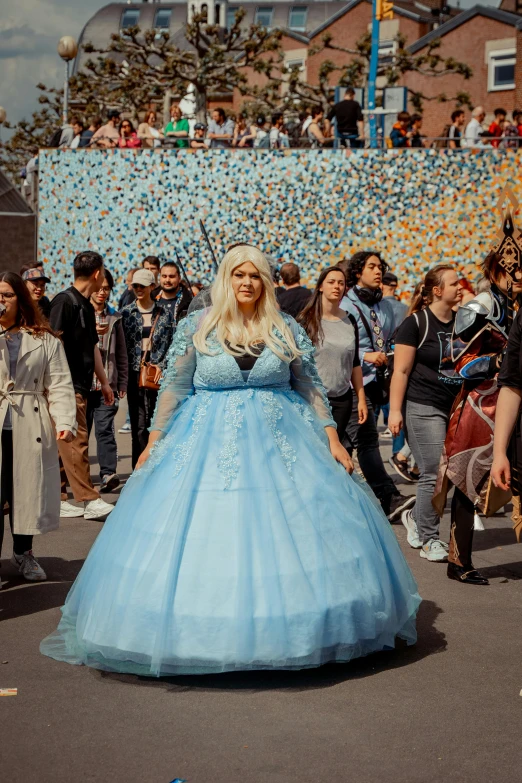 a woman dressed in a blue and black costume on the street