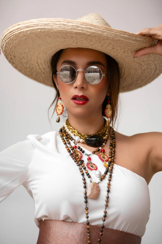 a woman in a white top with a hat and some jewelry