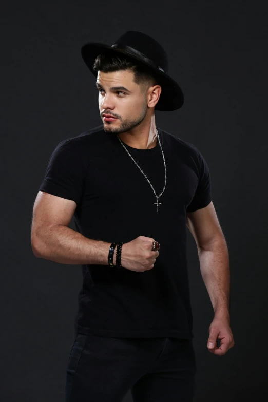 man wearing hat and jewelry posing in the studio