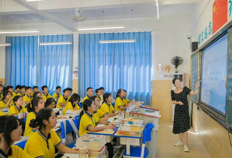 an asian female teacher talking to a class of students