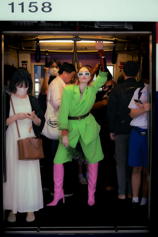 an asian girl dressed in green stands next to a group