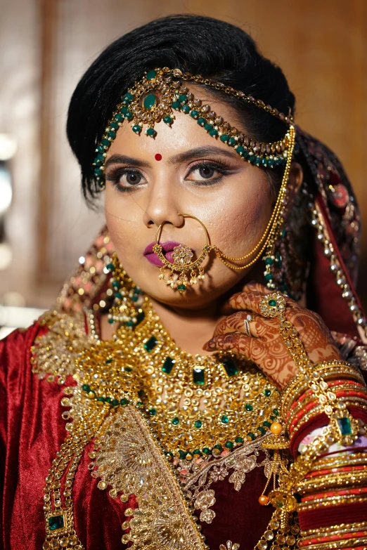 an indian bride with head decoration wearing gold jewelry