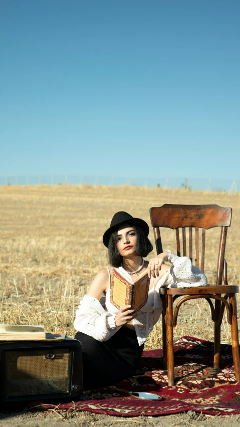 a woman sits in front of a chair on top of a rug