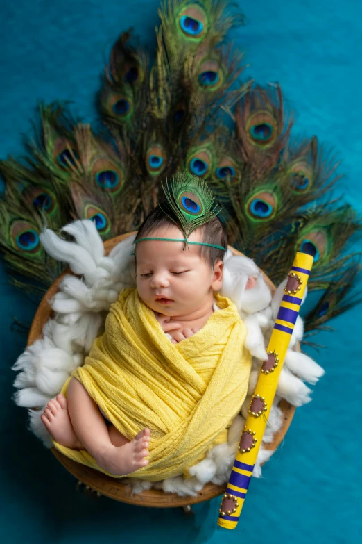 the baby boy is sleeping on top of the bird feather