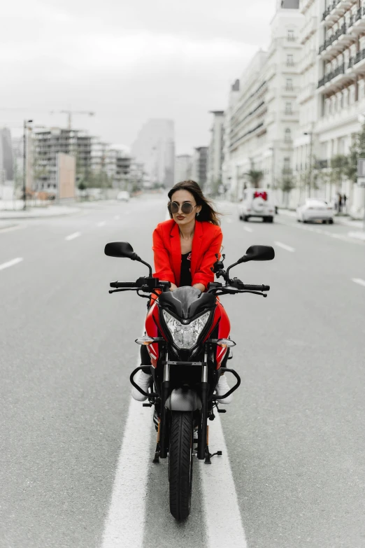 a woman wearing sunglasses is riding a motorcycle