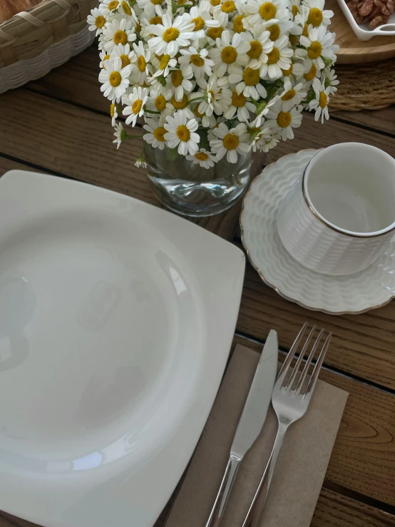 there is a plate on a wooden table with some white flowers