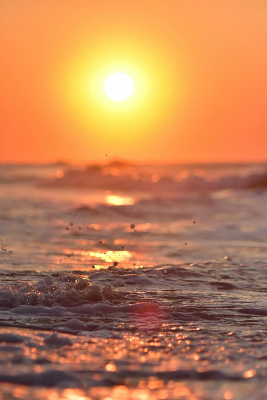 waves rolling across the ocean at sunset