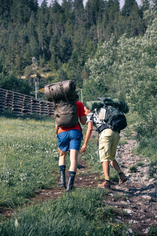 two men hiking in the mountains with their backpacks on