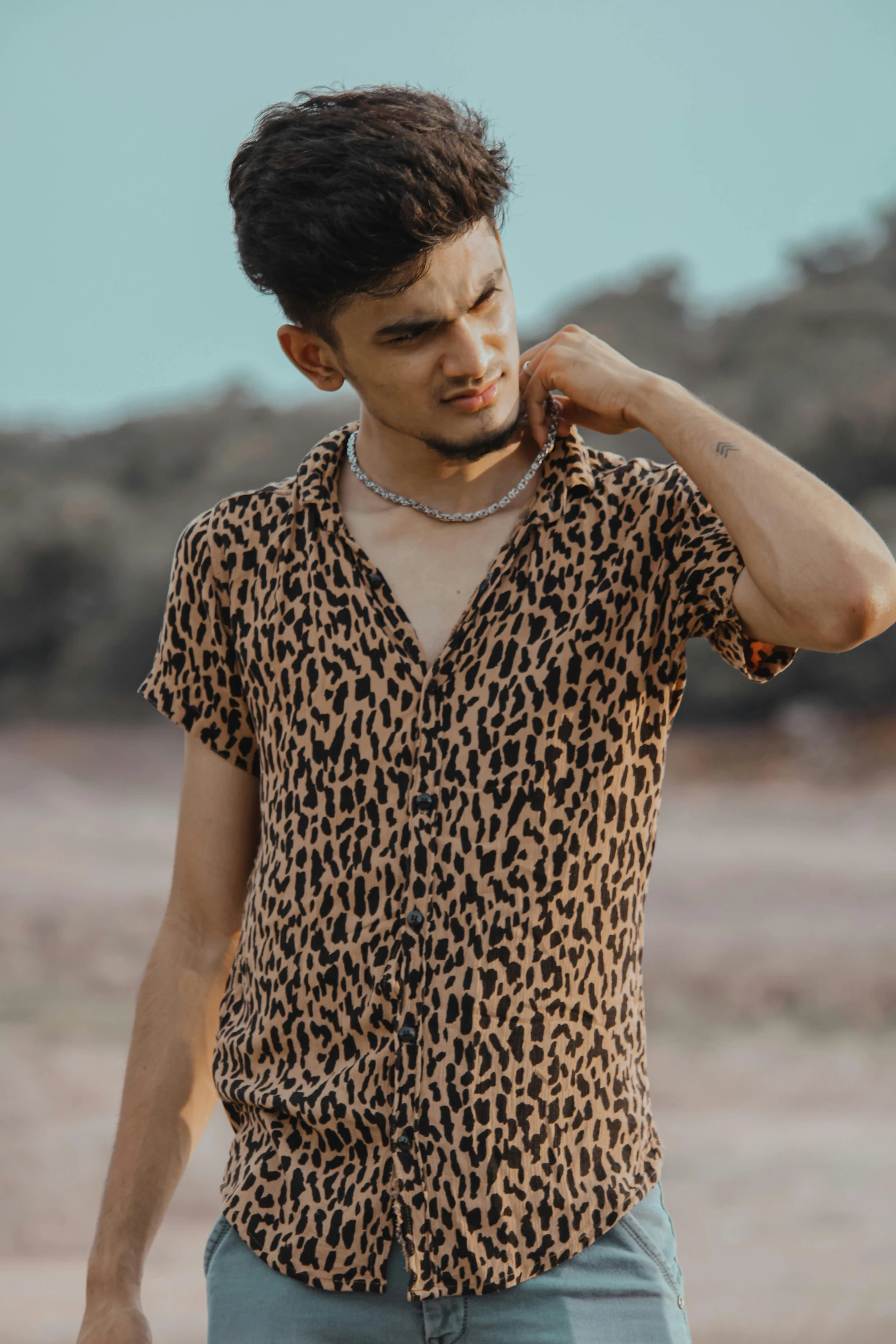 a man wearing a short sleeve leopard print shirt