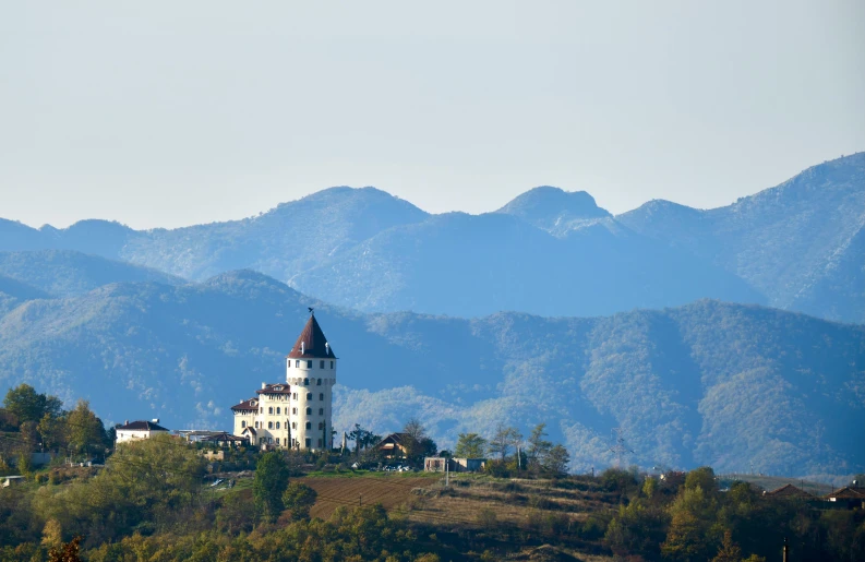 a white building in the middle of a mountainous valley