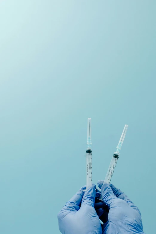 person's hands holding an iv pipe against blue sky