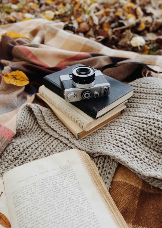 an old book is laying on a bed with a vintage camera and book