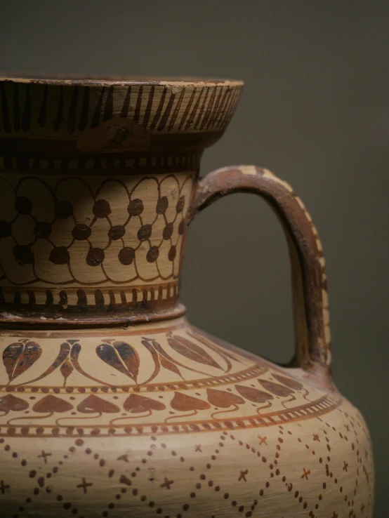 a brown vase with small designs on the outside of it