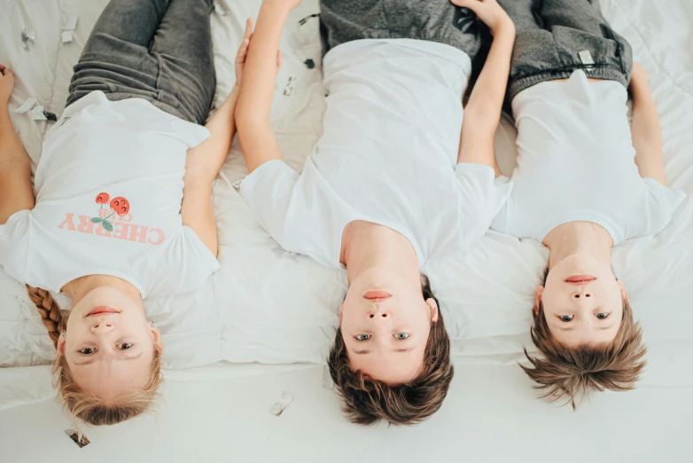 three people are laying in a bed