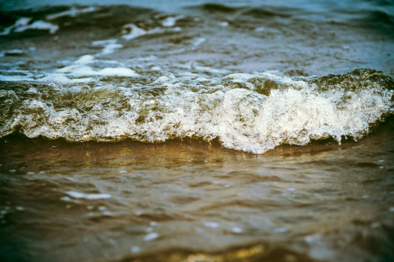 the water is splashing onto the beach shore