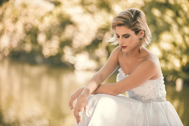 a woman in a dress sitting next to some water