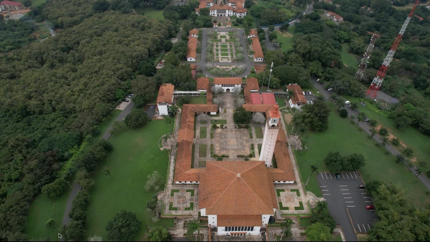 an aerial view of a building surrounded by lush green trees