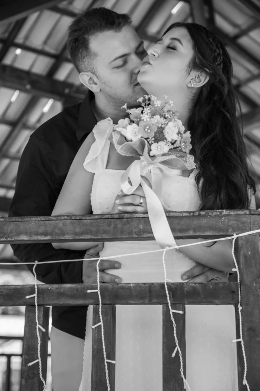 the bride and groom kiss on the balcony