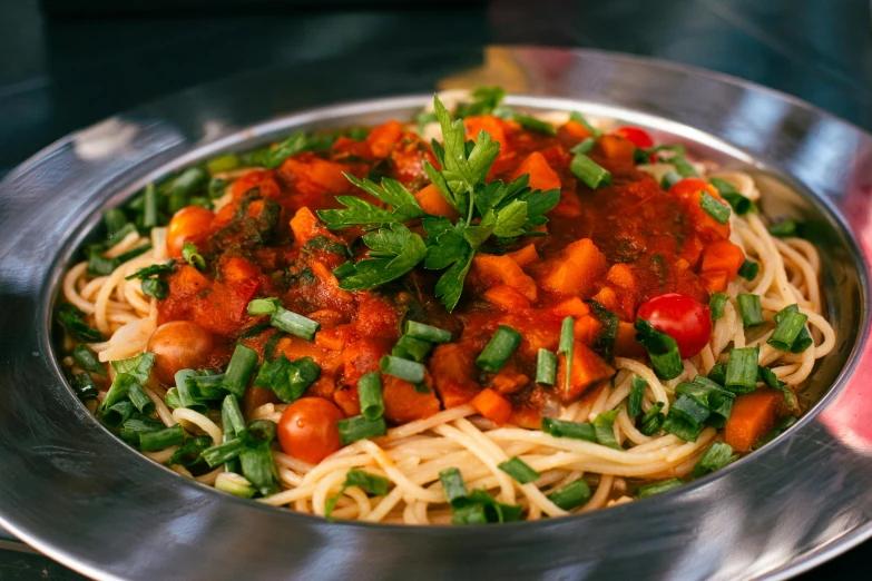 a large metal pan with noodles and vegetables in it