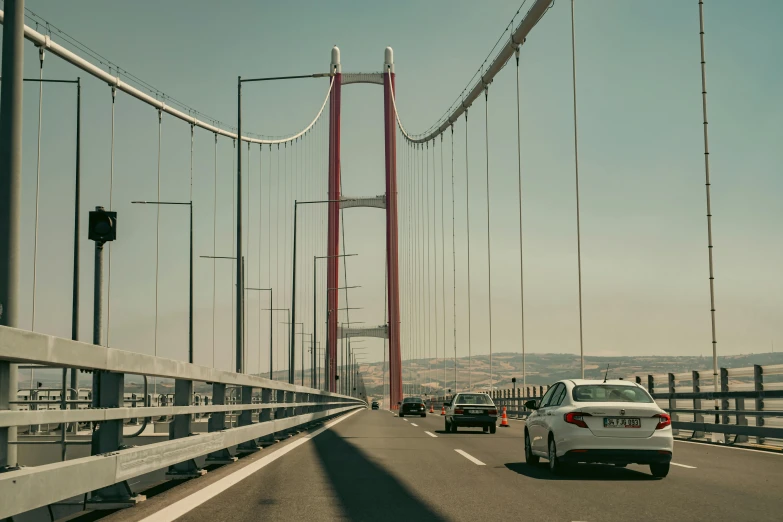 a large white car driving over a bridge