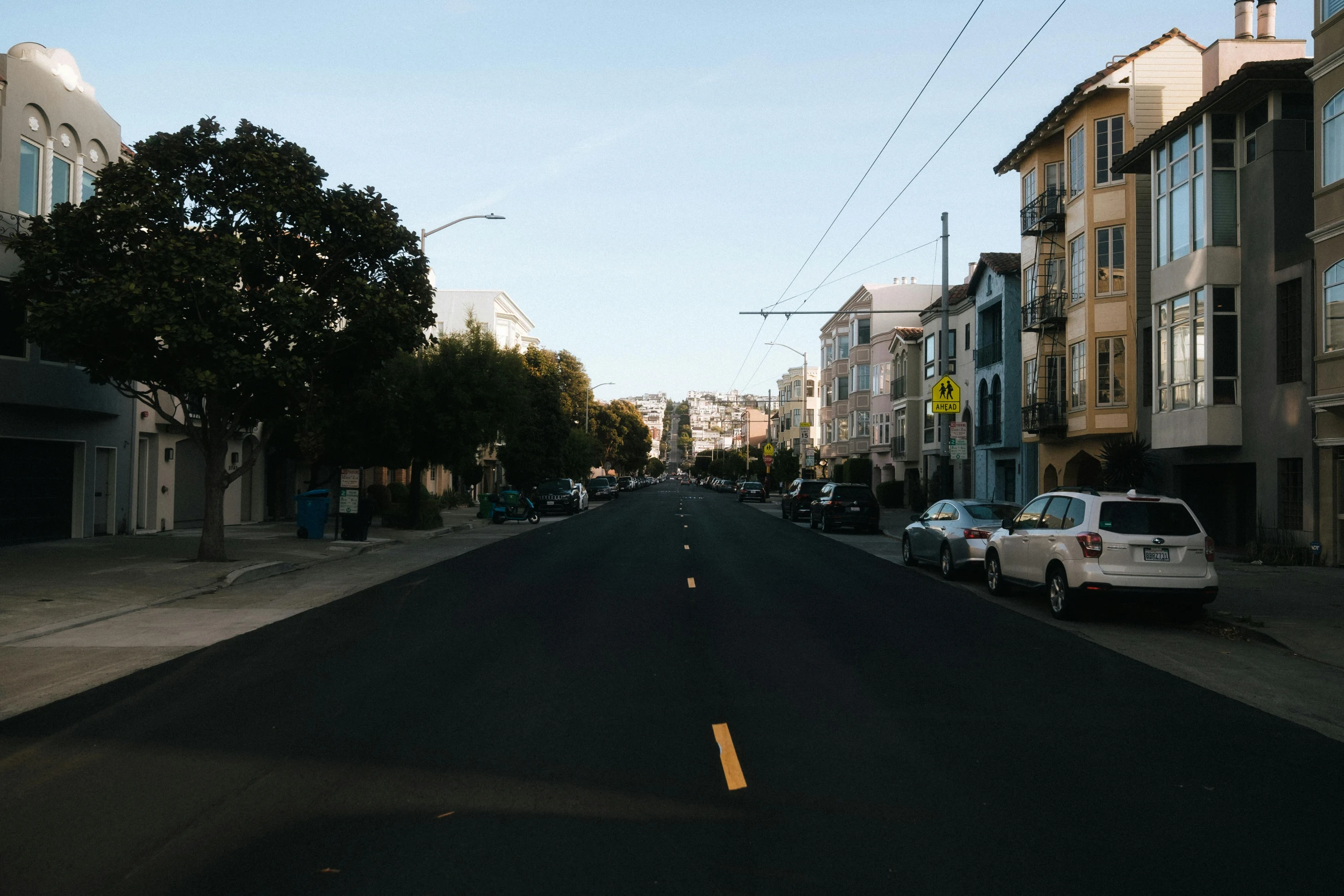 cars are parked along the street in a residential area