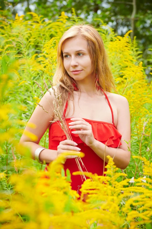 a woman in a red dress holding a flower in her hands