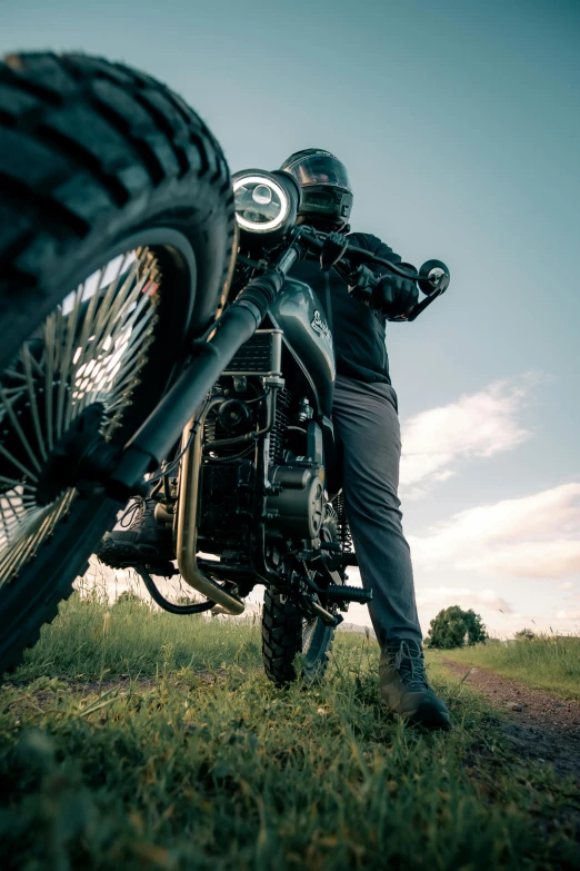 a man is sitting on a motorcycle while looking at the sky