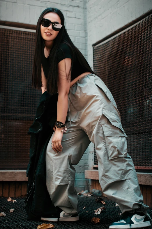 a woman in sunglasses crouching on a floor