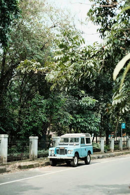 an old fashioned truck is parked along the side of a road