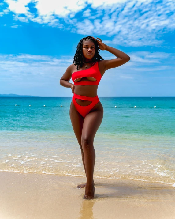 an attractive woman in a red bathing suit on the beach