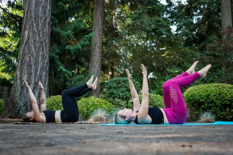 two women doing downward back stretches on their mats