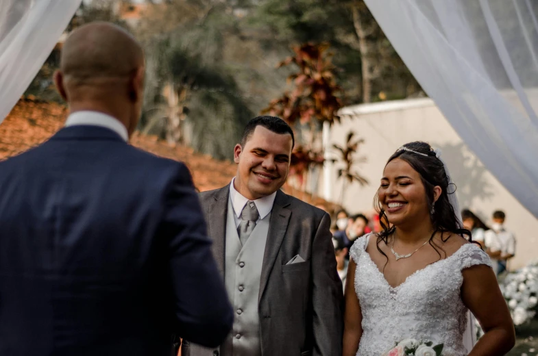 a smiling man and woman are standing by an altar