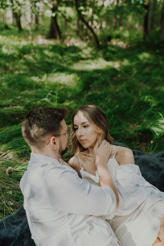 man and woman in white attire sitting on the ground