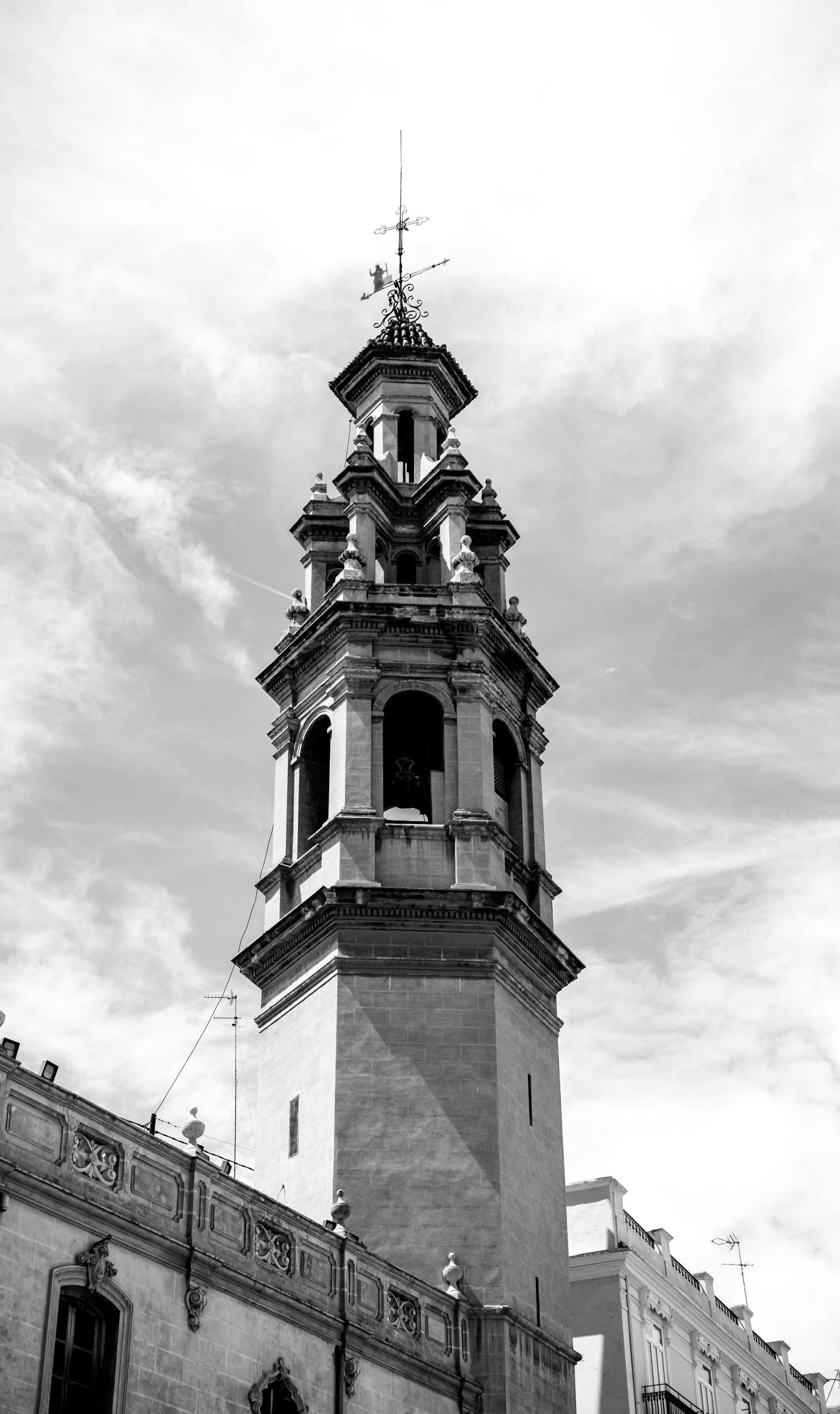 a clock tower with a weather vein on top of it