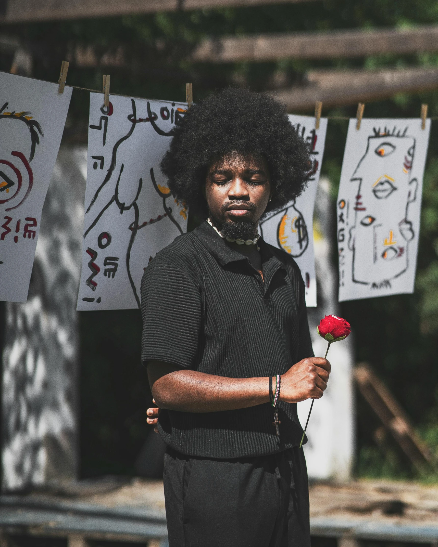 a man holding a flower is standing in front of posters