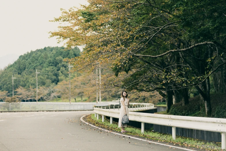 a person standing near a road on the side of the street