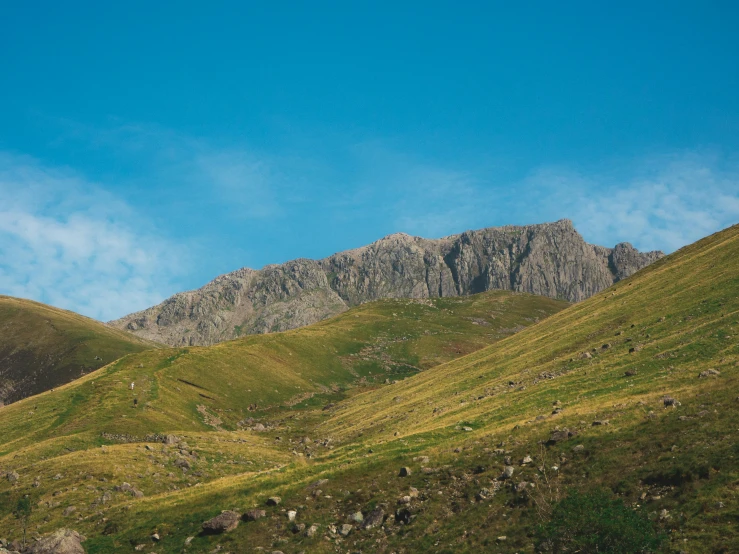 the mountain peaks are covered in green grass