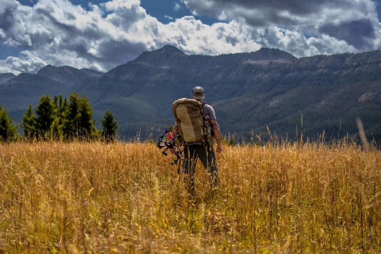 a person standing in the tall grass with his bike