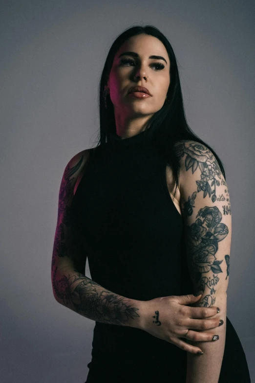 a woman with a black shirt, black leggings, and tattoos